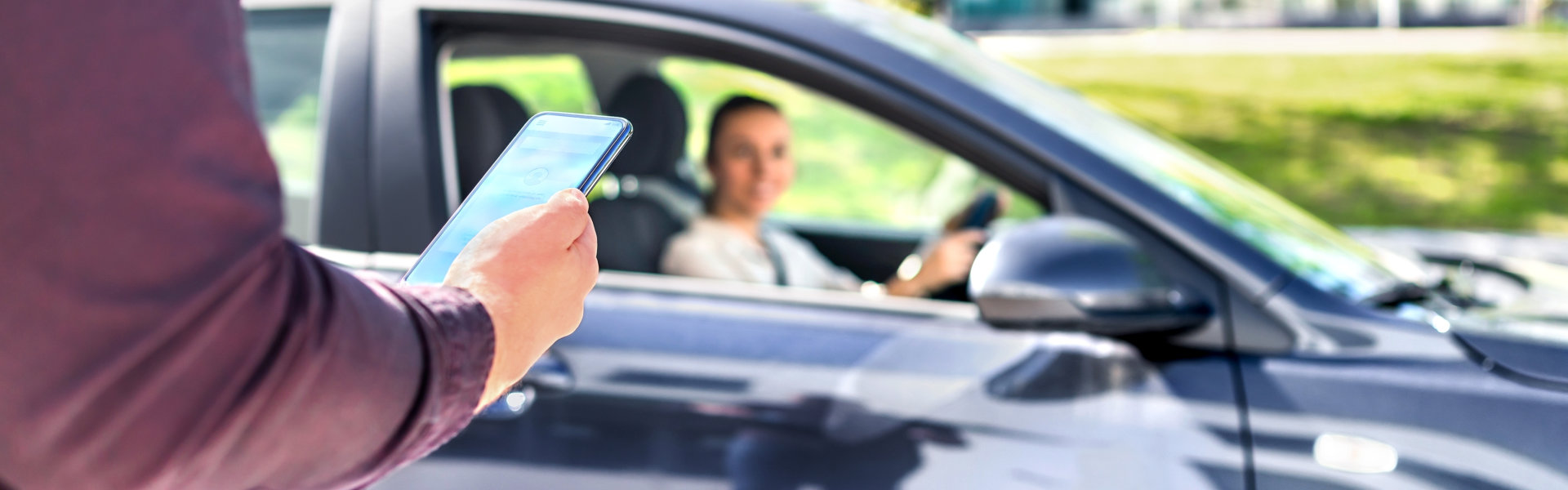 Man holding smartphone while waiting driver to pick up
